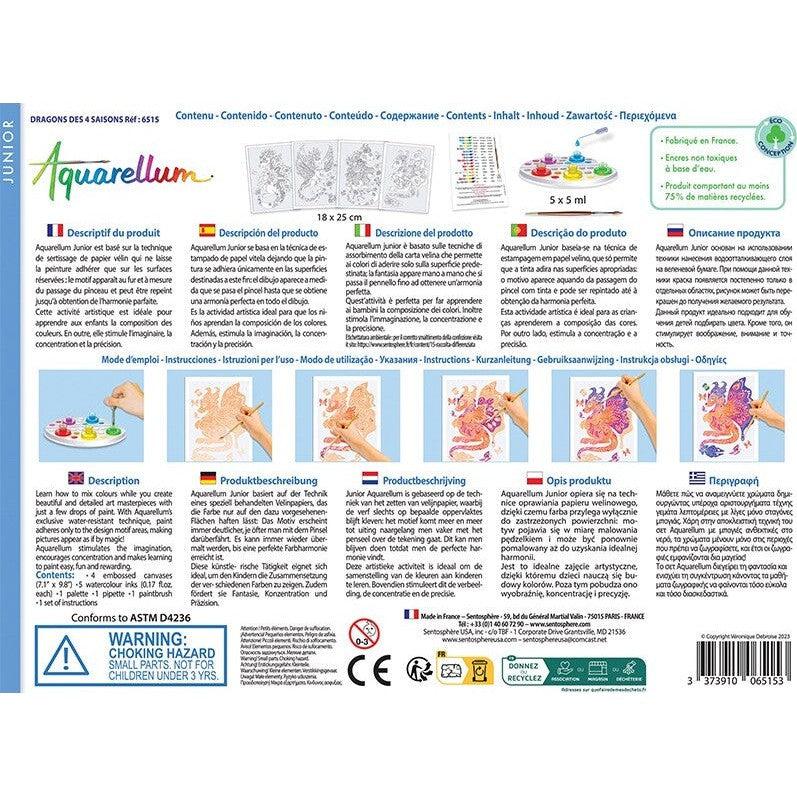 The Aquarellum Junior Dragons kit packaging features text descriptions in multiple languages, showcasing children's stunning dragon art masterpieces. It includes all necessary paint supplies and a safety warning for small parts.