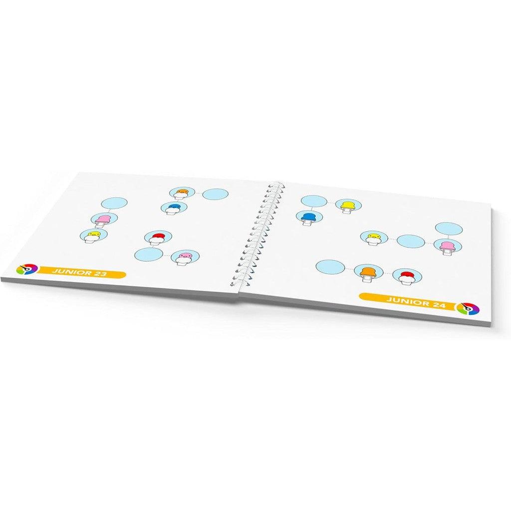 Open activity book with pages titled Junior 23 and Junior 24, featuring colorful mushroom illustrations within circles. Inspired by SmartGames, the vibrant designs offer a playful twist reminiscent of wooden deduction games.