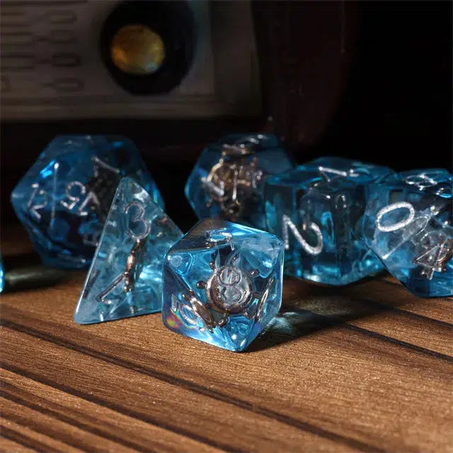 A set of translucent blue resin polyhedral dice with silver numbers rests elegantly on a wooden surface, perfect for enhancing your Role Playing Games experience.