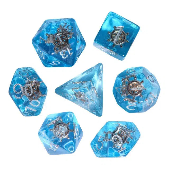 This set of transparent blue dice, perfect for role-playing games, features embedded silver nautical wheel designs in various polyhedral shapes and sides, crafted from premium resin.