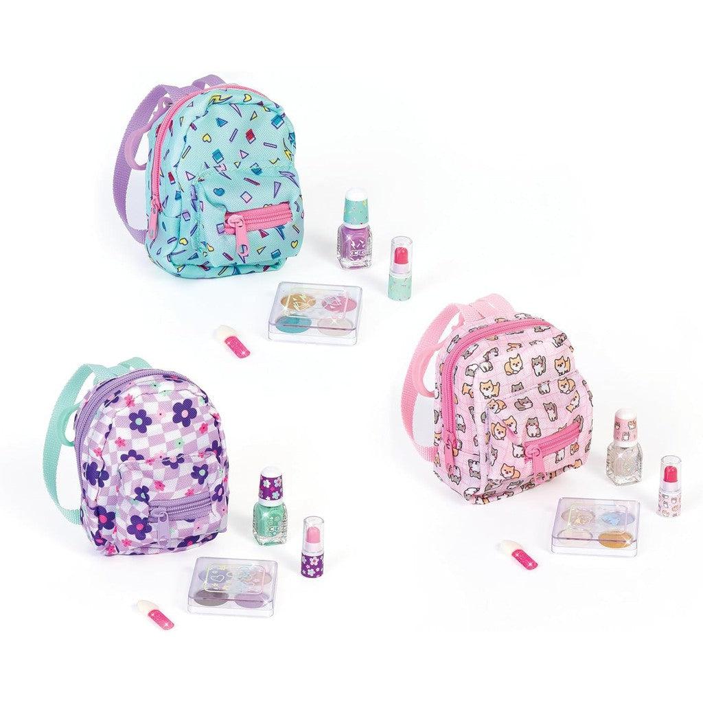 Three colorful mini backpacks from the Arcade Glam collection come with a kid-friendly mini cosmetic set, including nail polish, lip gloss, and stickers. Perfect for young fashionistas who want a touch of glam, all displayed on a pristine white background.