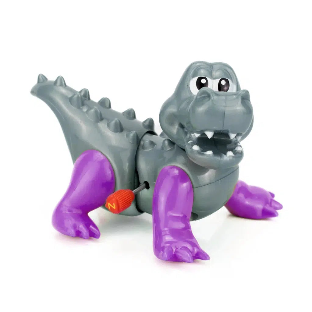 A gray and purple wind-up toy dinosaur, marked as part of the Z WindUps collection, features an orange key, open mouth, and spikes on its back. This delightful kids' toy is sure to capture imaginations as it roams around!