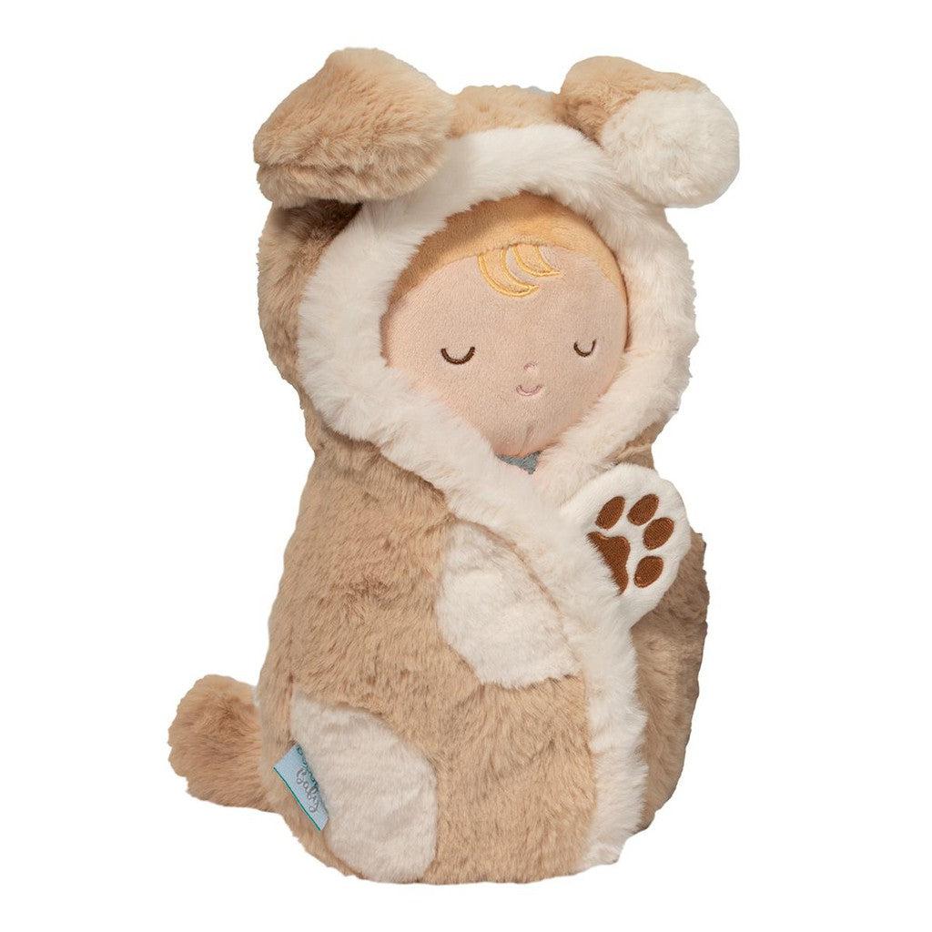 A cuddly baby doll dressed as a puppy, featuring a plush brown and white dog costume with closed eyes, floppy ears on the hood, and a paw print on one sleeve.