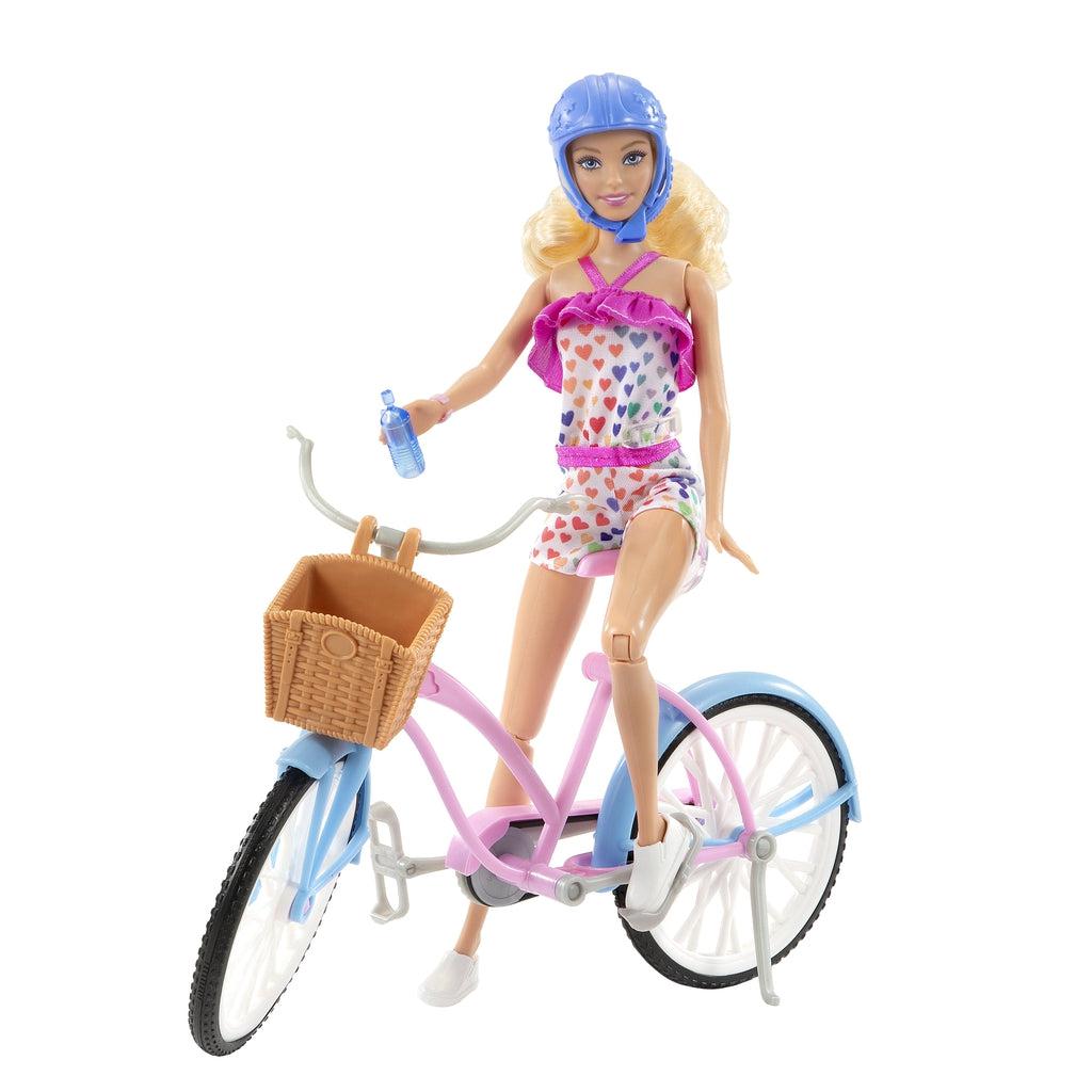 Shows Barbie with her helmet on riding the bicycle and holding a water bottle.