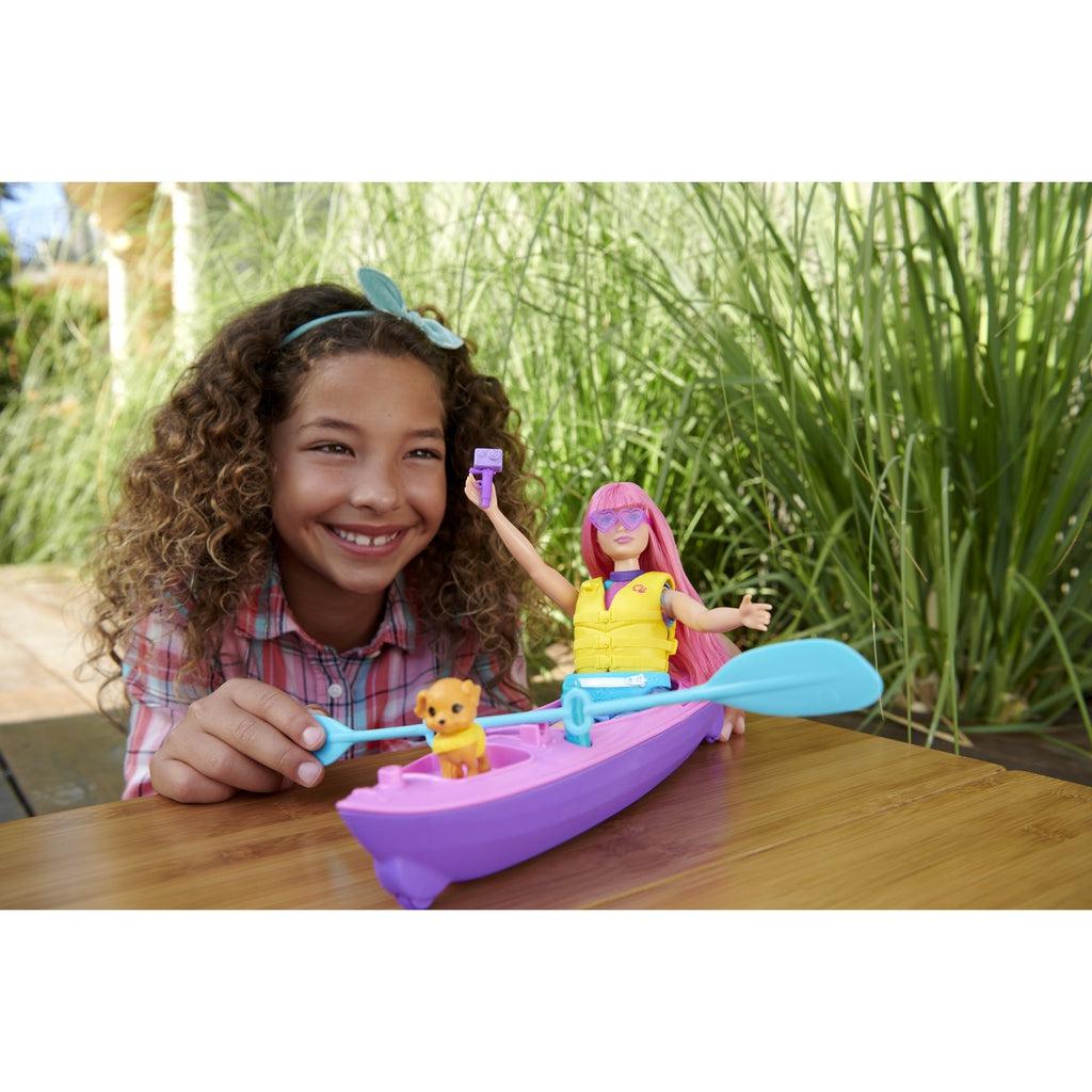 Scene of a little girl smiling while helping Daisy paddle her kayak.