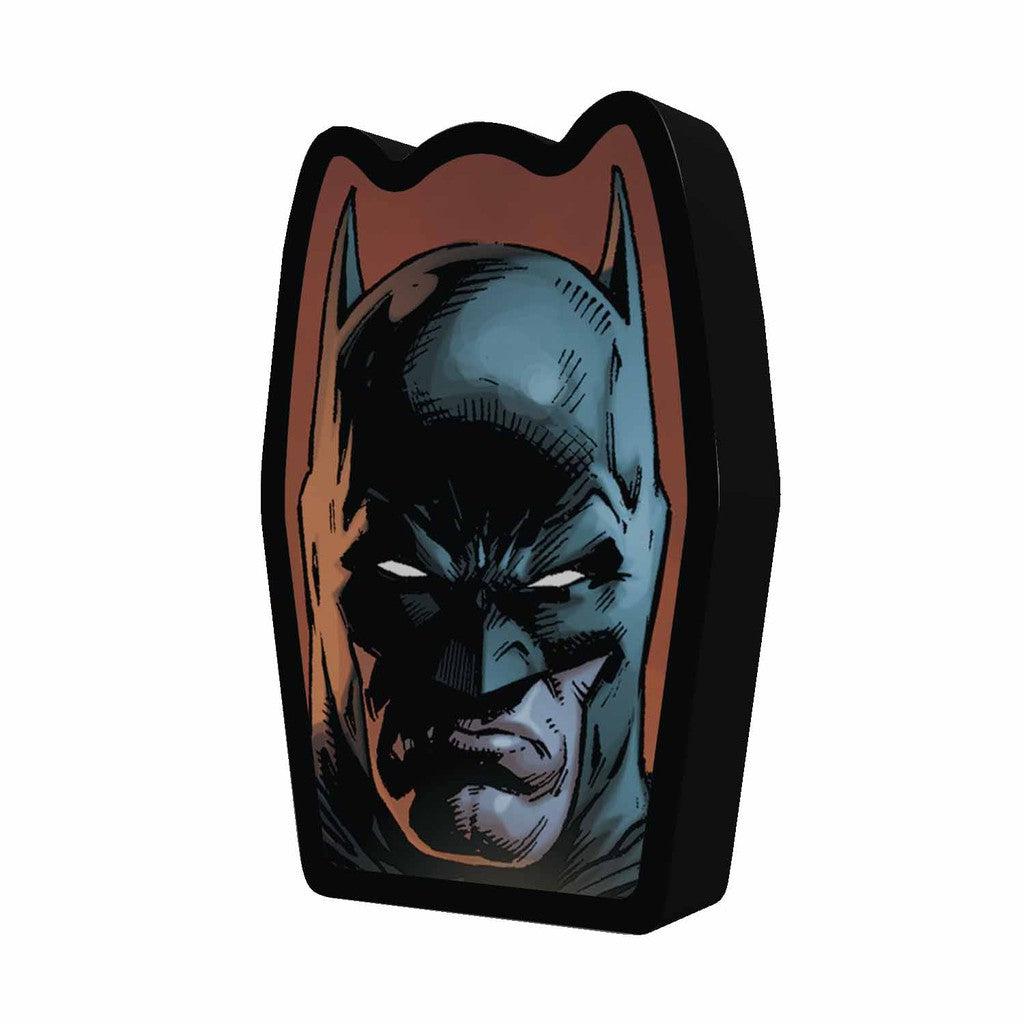 Cartoon-style illustration of Batman's masked face, with pointed ears and a serious expression, in a coffin-shaped frame, reminiscent of classic DC Comics art.