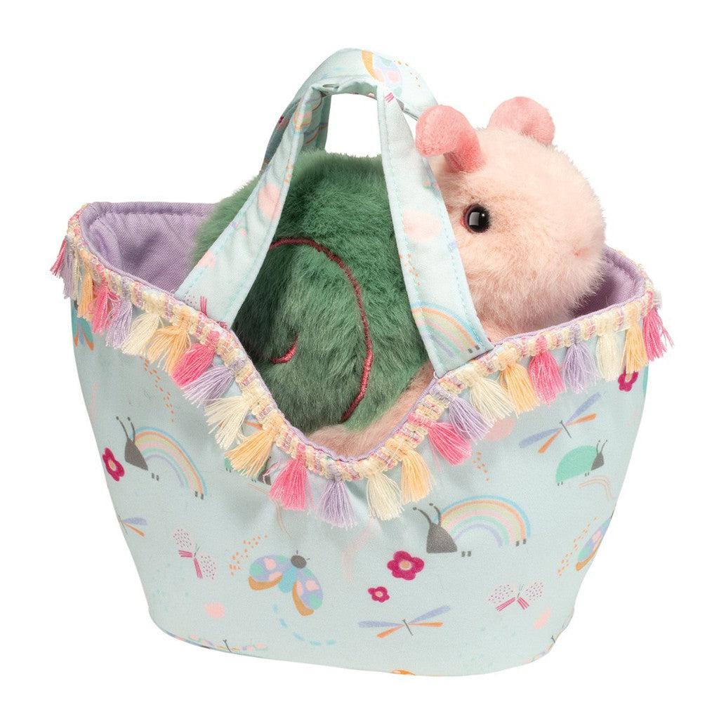 A Beautiful Bugs Sassy Pet Sak cradles a plush guinea pig toy, nestled in a pastel-colored patterned fabric basket adorned with tassels—perfect for your collection of springtime accessories.