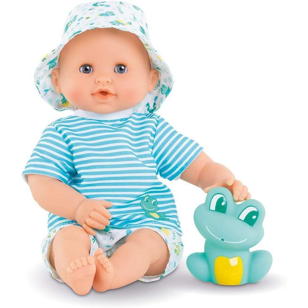 Baby doll wearing a striped blue outfit and a matching hat, sitting next to a blue frog toy.