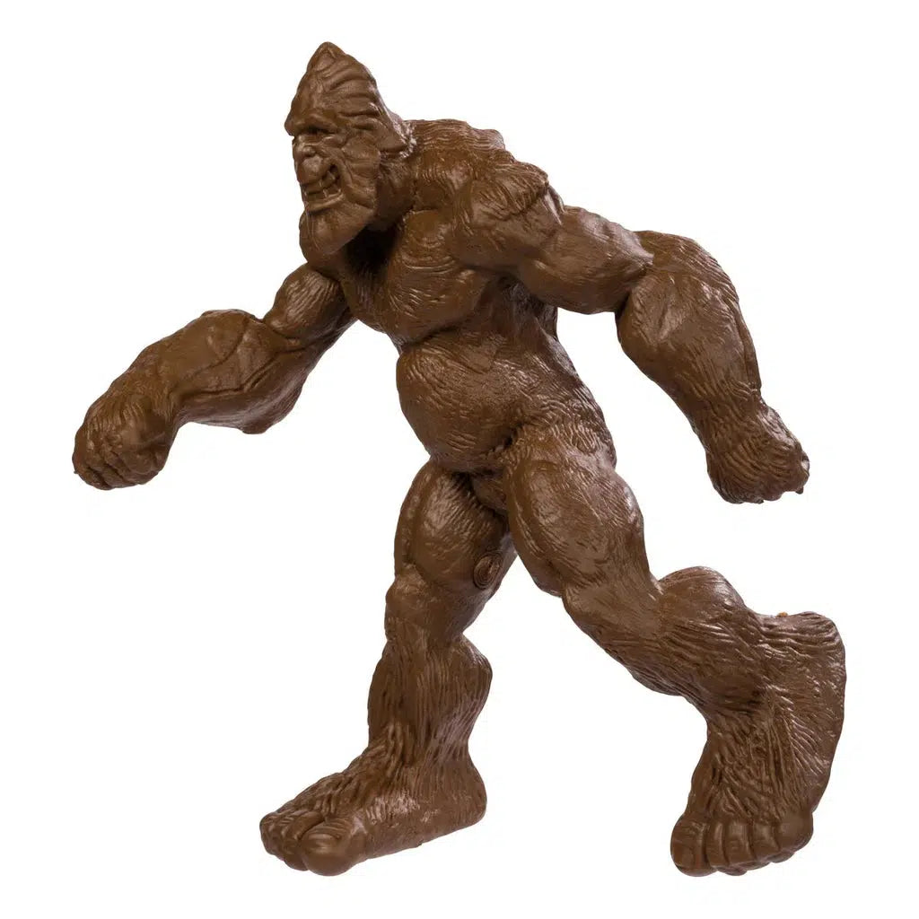 Brown Bigfoot toy figurine with exaggerated features and large feet, featuring bendable limbs that enhance its playful design, posed in a walking stance on a white background.