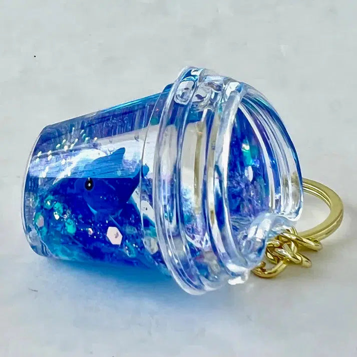 heart-shaped cup keychain with blue dolphin inside