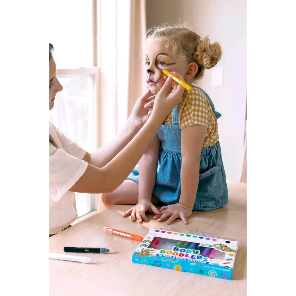 person drawing on a child's face with ooly body doodlers