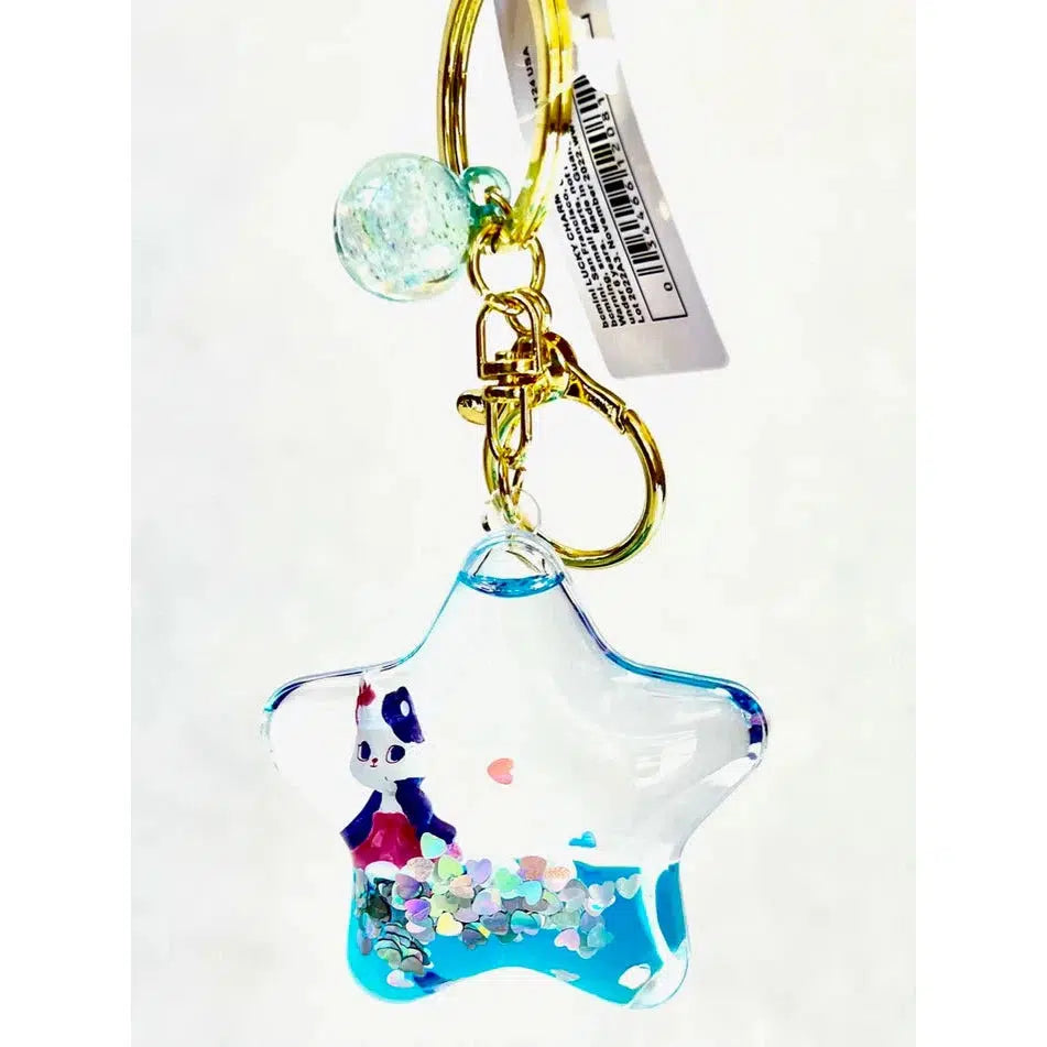 This star-shaped keychain features a whimsical little figure inside, surrounded by colorful confetti and a gold keyring clip. Perfect for fans of silly animal charms, it comes with a price tag attached.