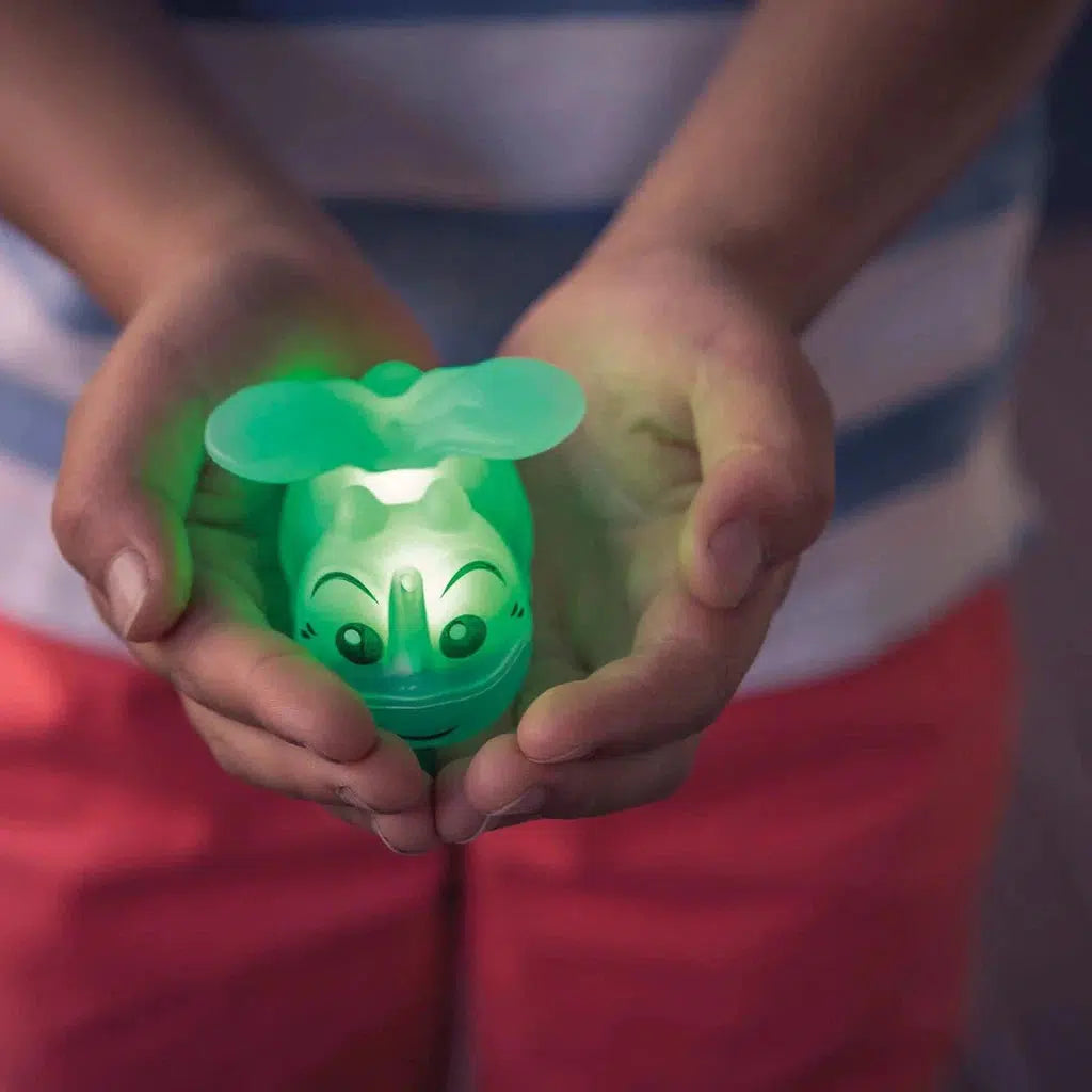 hands holding a light up firefly toy