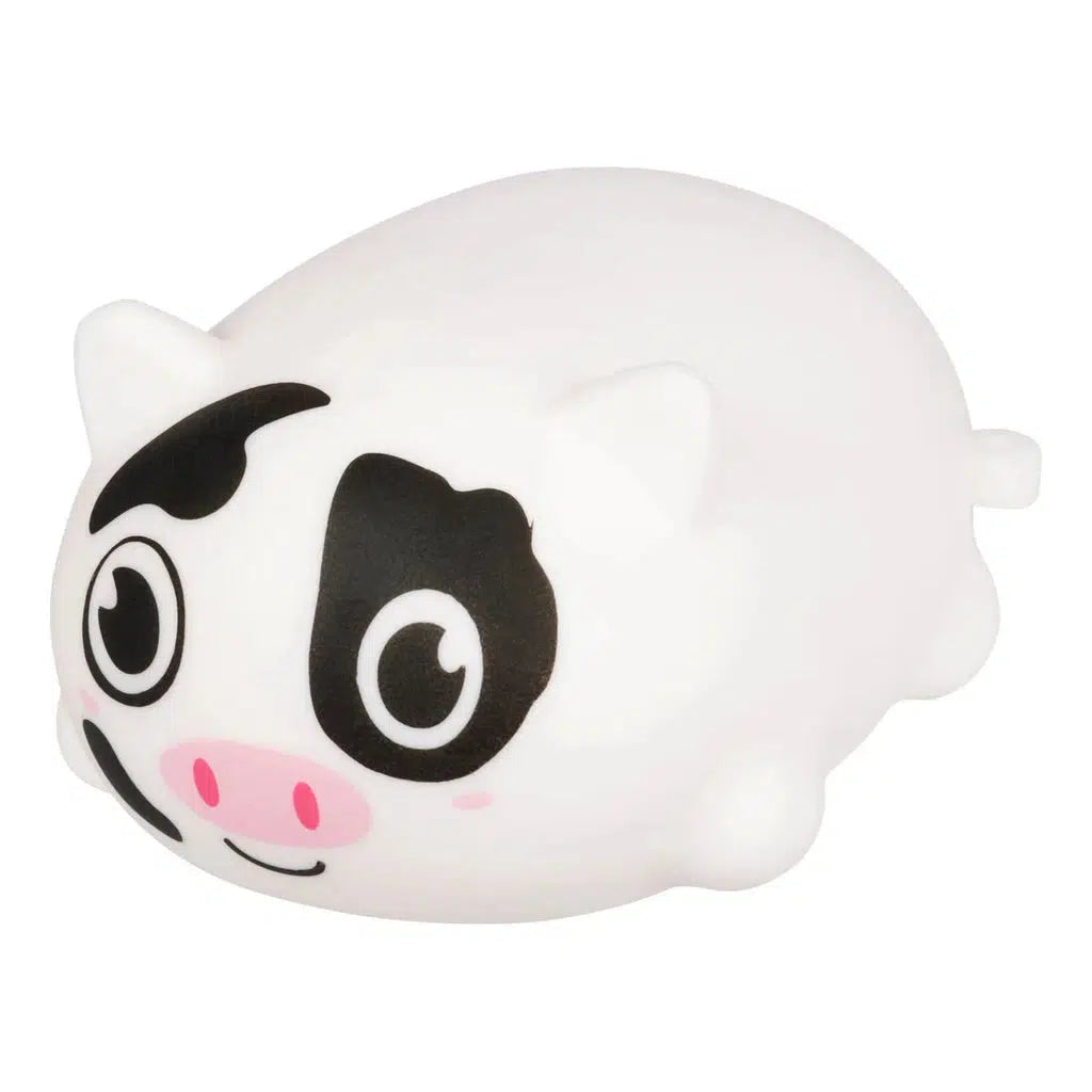 The Farm Fresh toy features a small, round, white cow with black spots and large eyes, perfect for stress relief. This squishy barnyard animal ball is set against a plain background, capturing its charming simplicity.