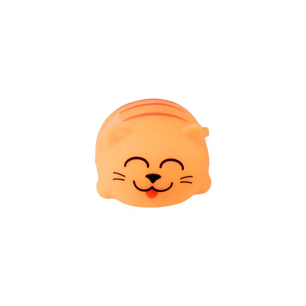 A small, orange Toysmith stress relief squish ball shaped like a chubby kitty, with a smiling face and closed eyes.