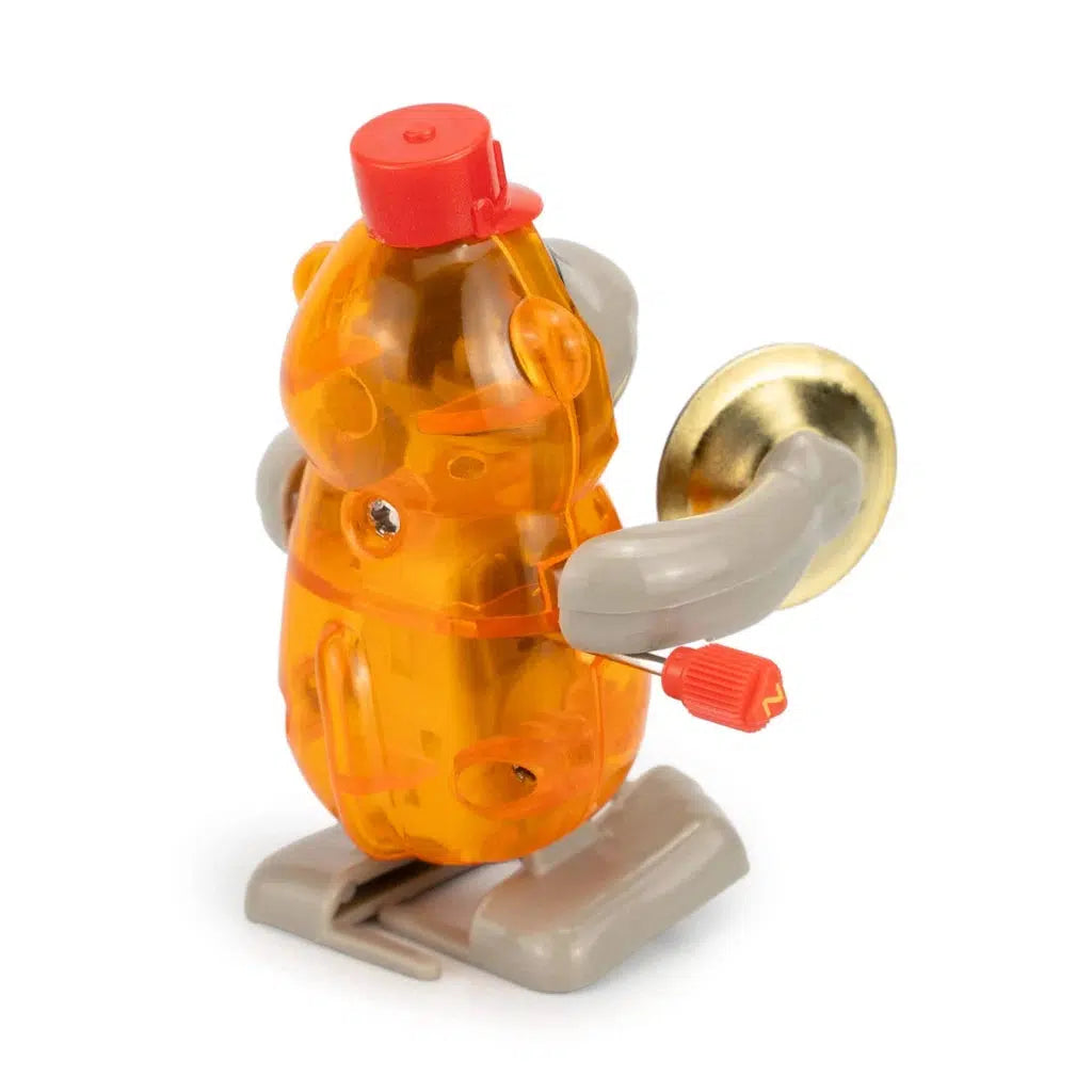 This charming retro toy features a transparent orange body and grey limbs, topped with a jaunty red hat. The wind-up toy monkey comes to life with its vibrant red key, holding a brass cymbal. A delightful addition to any vintage toys collection!