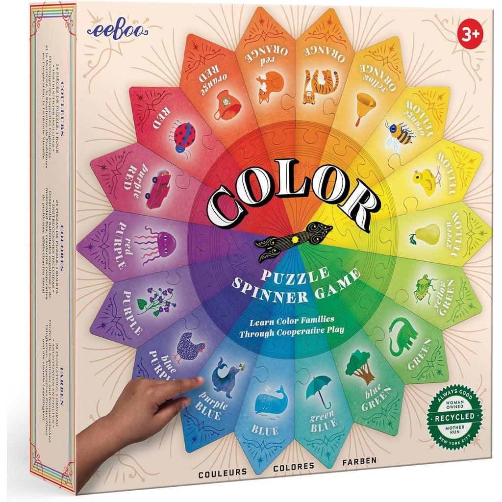 Color Puzzle Spinner game box with a vibrant rainbow wheel design. An educational cooperative game featuring color names and images of objects, perfect for kids ages 3+. Text available in multiple languages for inclusive fun.