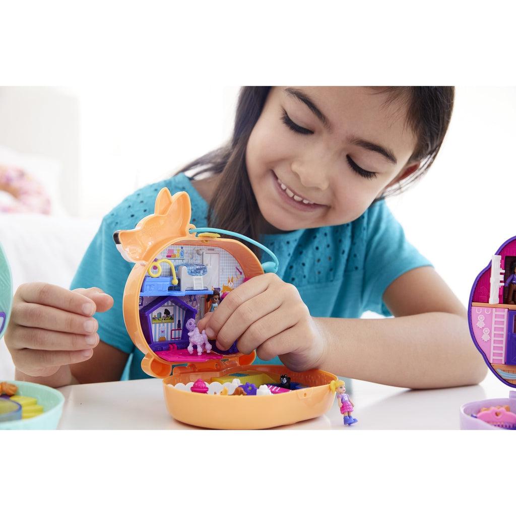 Young girl playing with open compact on table.