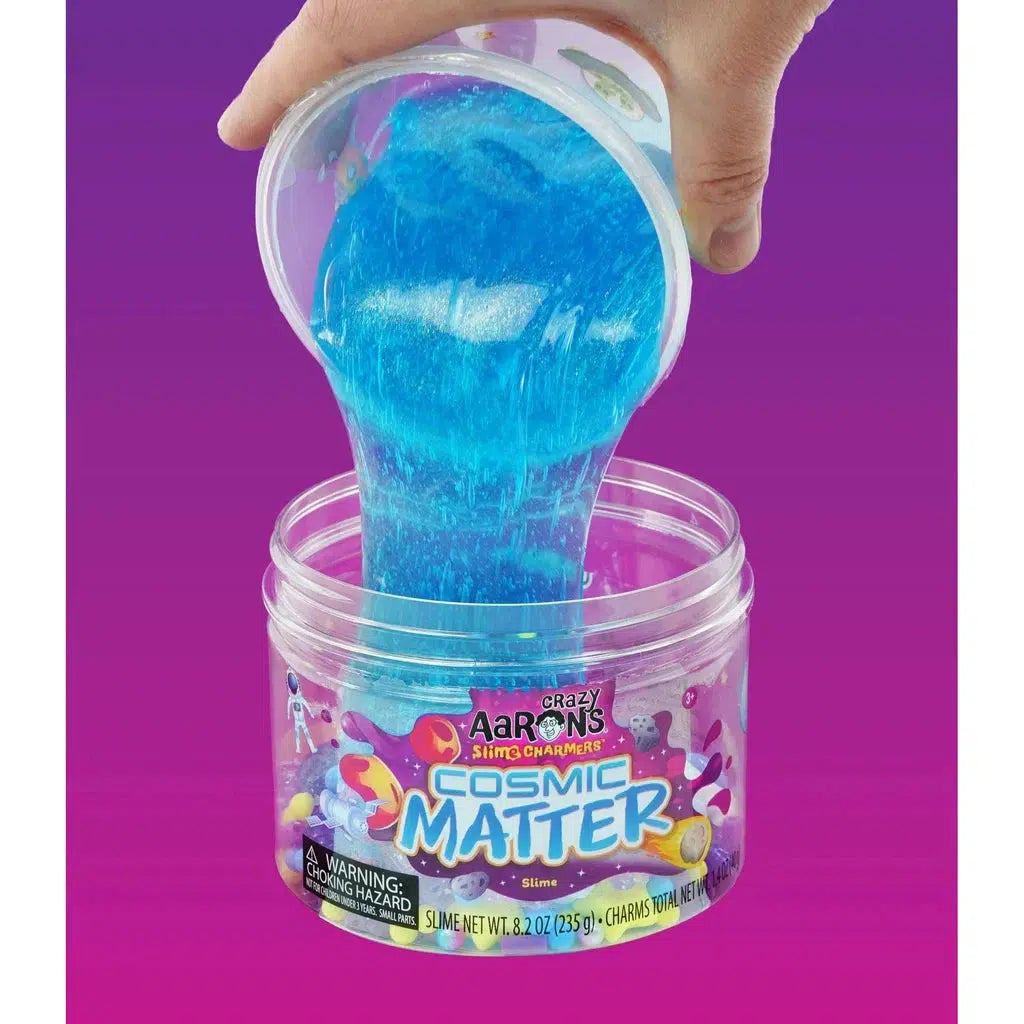 Hand dumping slime into tub of charms