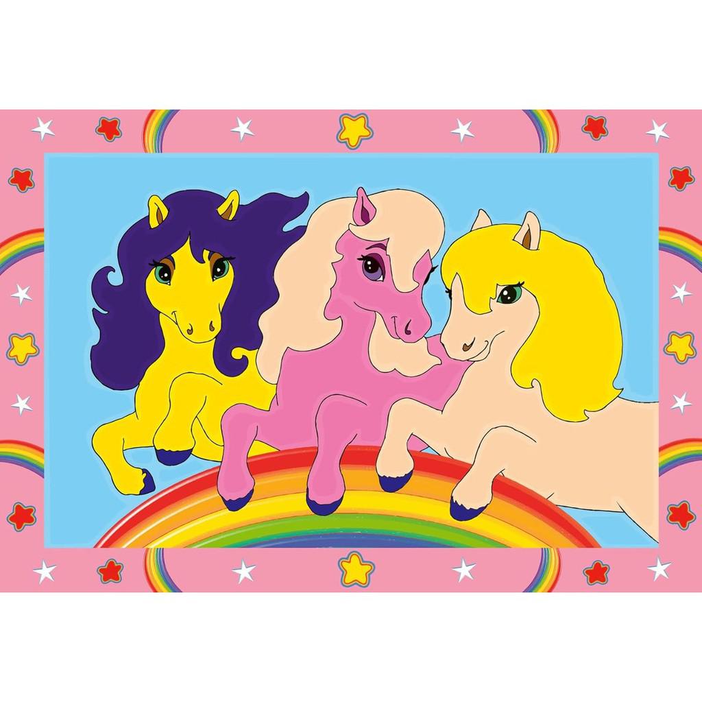 Three cartoon ponies on a rainbow surrounded by a pink border. One pony is yellow, one is pink, and one is orange