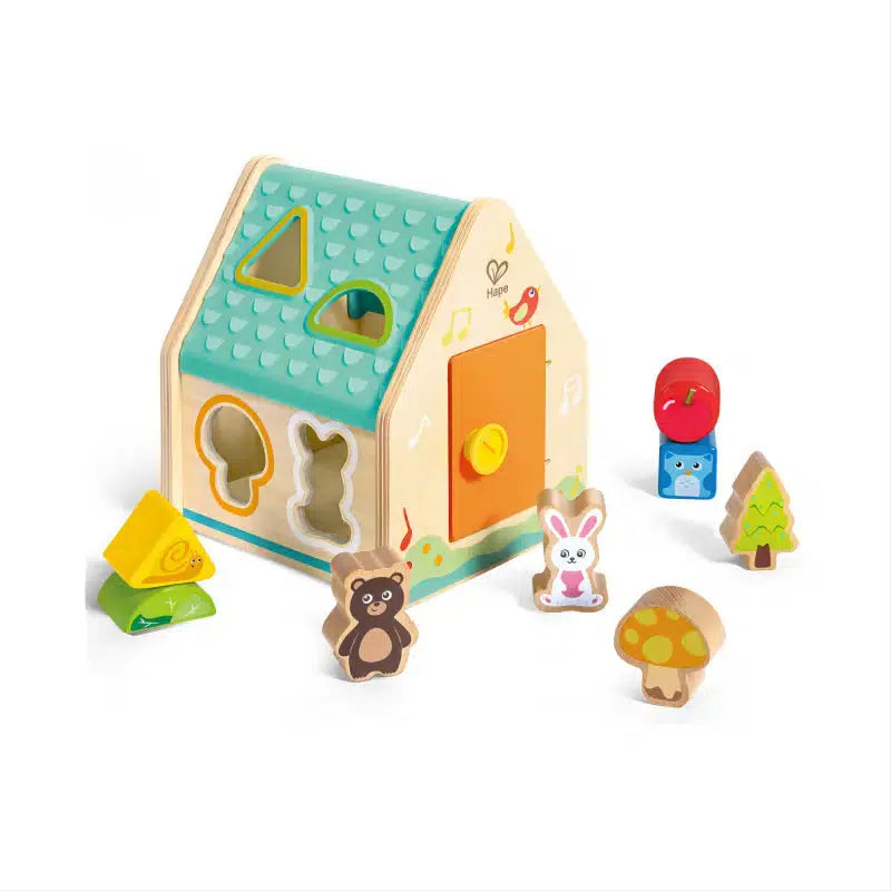 This charming wooden toy house by Hape Toys features delightful shape-sorting elements, complemented by animal, tree, and mushroom wooden pieces.