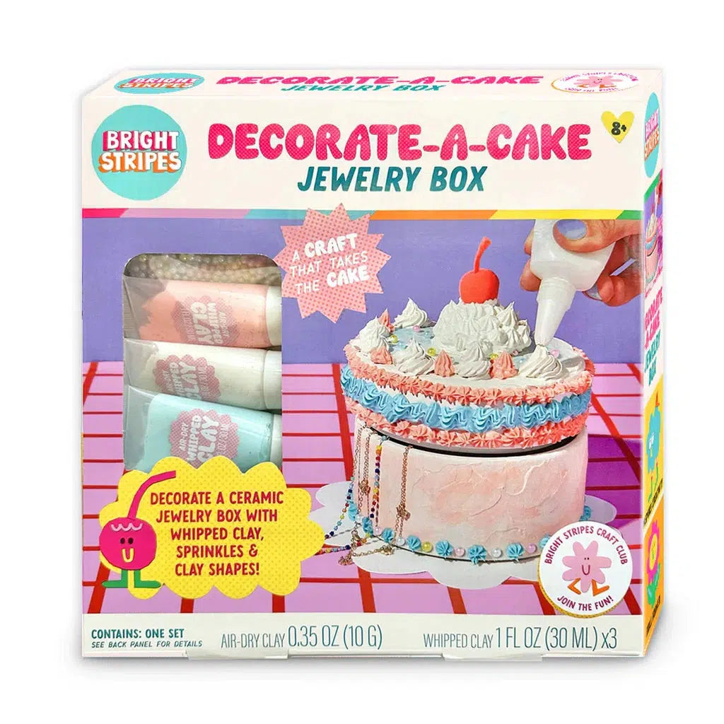 Box of "Decorate-A-Cake Jewelry Box" craft kit for ages 8+, featuring air-dry clay and whipped icing clay for decorating a ceramic cake-themed jewelry box.