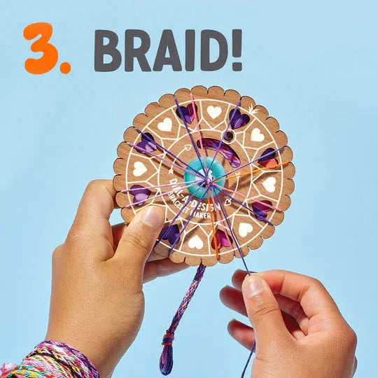 Hands holding a circular braid maker with colorful embroidery floss against a blue background. A vibrant "3" and the word "BRAID!" adorn the top left corner, perfect for adding flair to your Craft Club gift tags or creating a unique laser-cut wood bracelet.