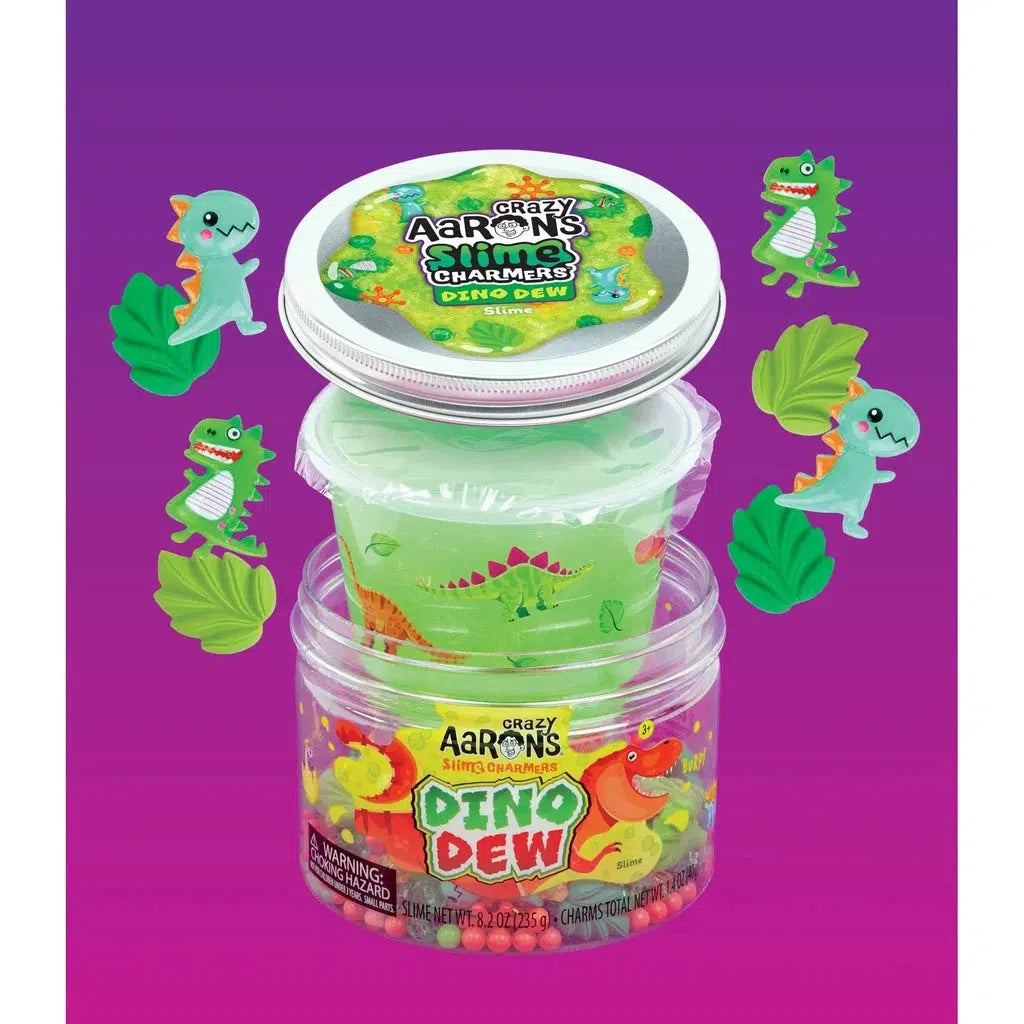 Dinosaur charms next to tub of slime