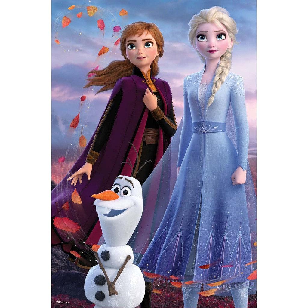 Anna and Elsa from Frozen stand beside Olaf, surrounded by falling leaves, against a scenic backdrop.