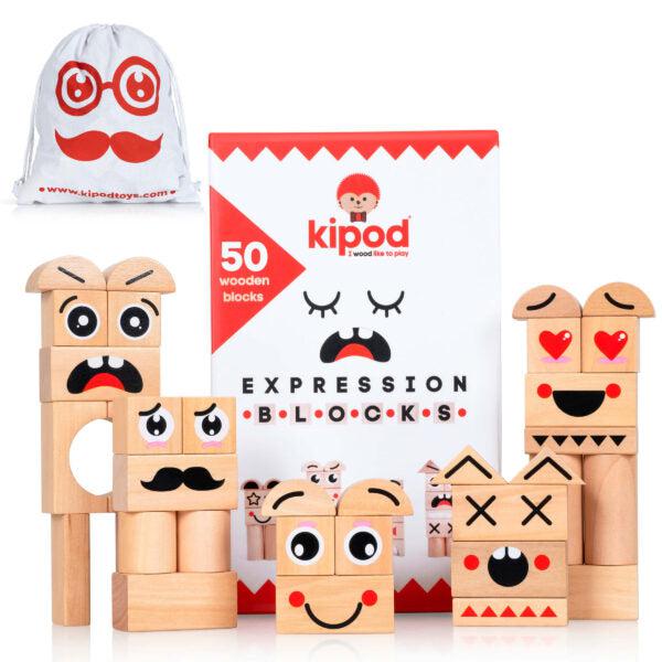 A set of 50 open-ended wooden building blocks by Kipod. The image shows various face designs using the blocks, a box with a sad face illustration, and a drawstring bag in the background. Perfect for kids to play and build Cars, Animals, or Buildings.