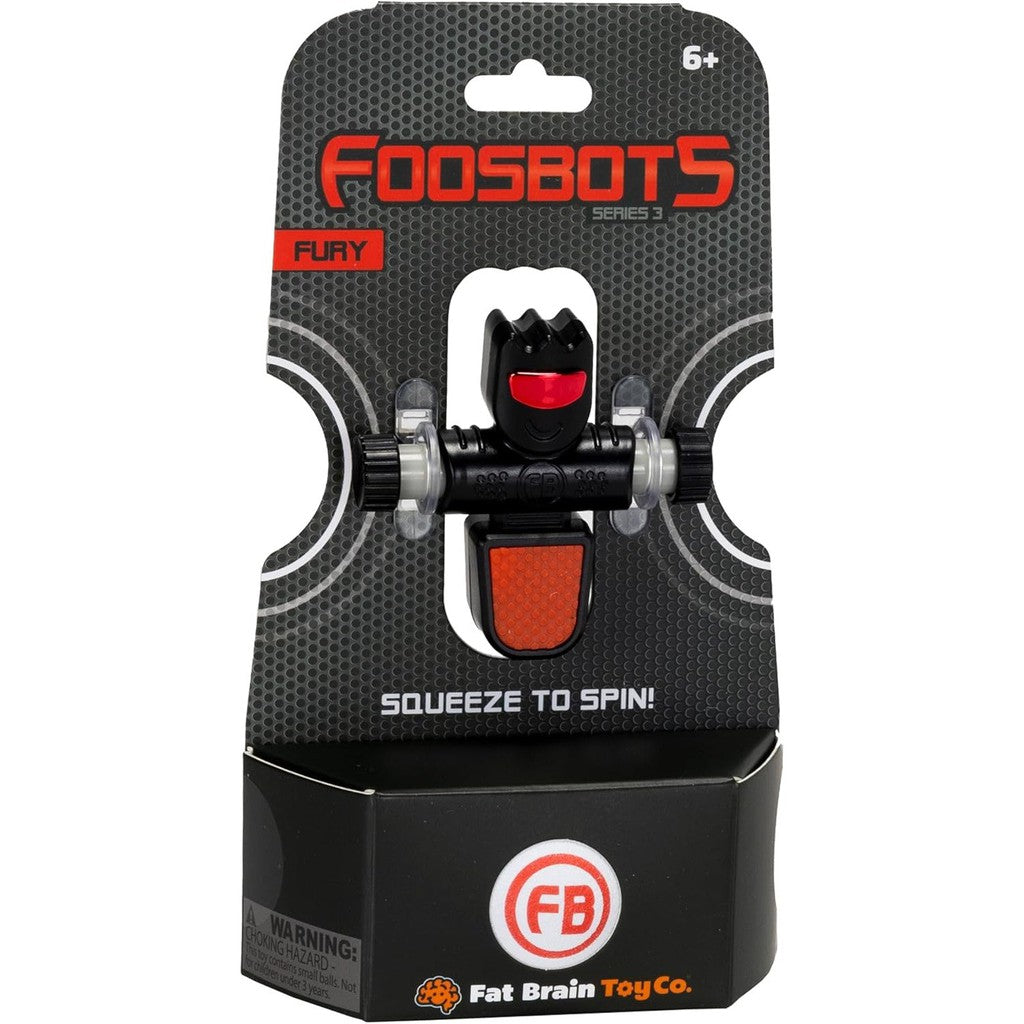 Packaging of the Foosbots Fury toy by Fat Brain Toys, part of the thrilling Foosbots Series 3. Featuring a dynamic black and red spinning figure, it's designed for active play and is suitable for ages 6 and up.