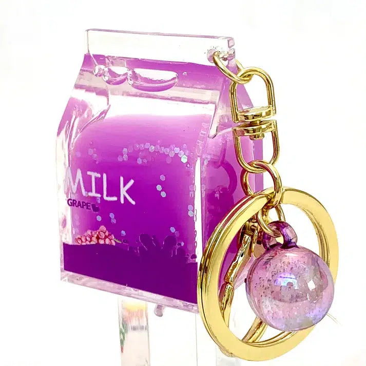 Purple grape-scented milk carton keychain with a gold ring and a decorative purple orb attached, perfect as a quirky backpack key charm.