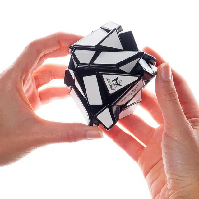 Hands holding a complex black and white puzzle cube with irregular shapes.