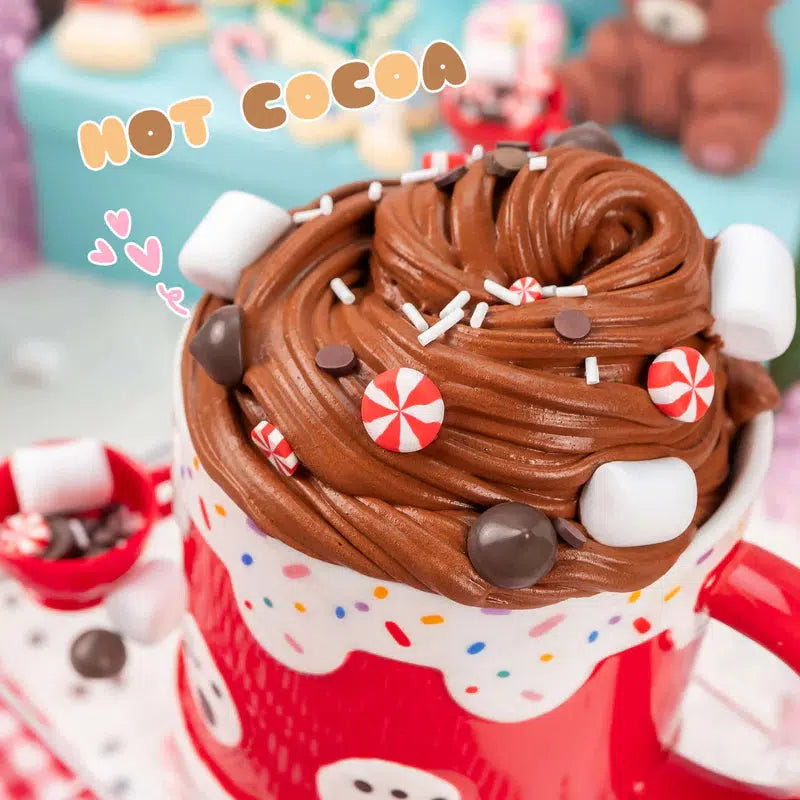 Red mug filled with creamy hot cocoa topped with marshmallows, chocolate chips, and candy pieces, with "Hot Cocoa" text above.