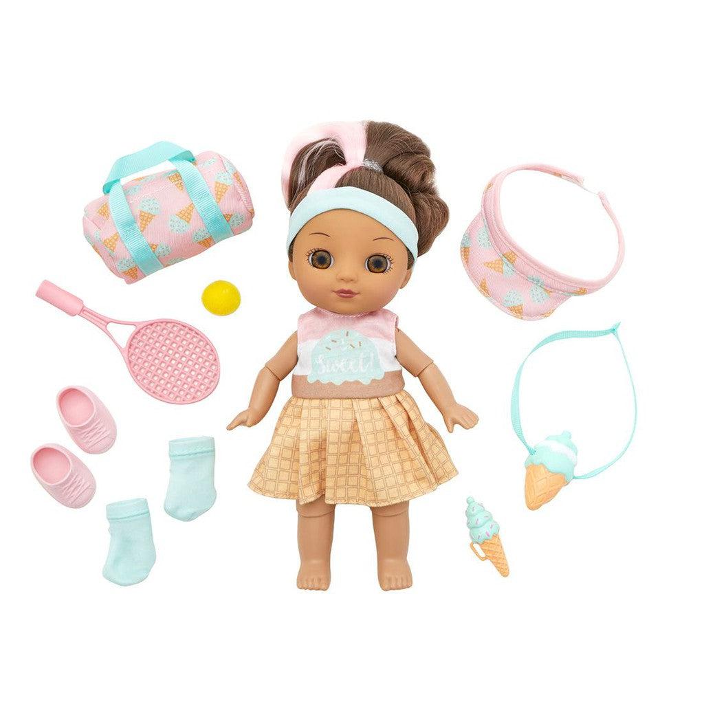 A tennis doll with brown hair, wearing a headband and skirt, is surrounded by delightful accessories. She has a chic bag, visor, shoes, socks, and her own tennis racket with a ball. Completing the set are a charming necklace and an adorable ice cream toy for added fun.