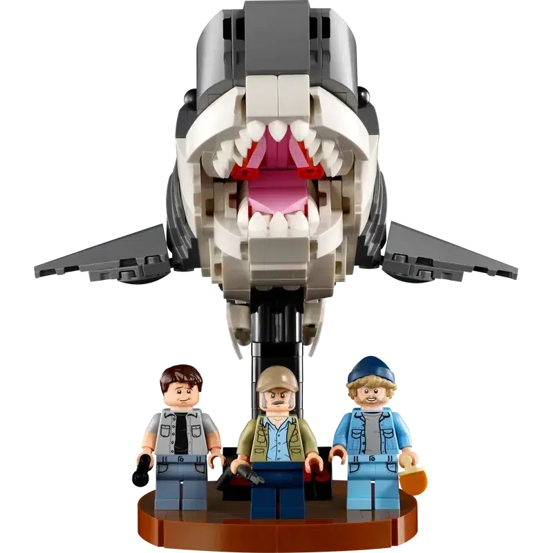 LEGO figures of three people stand on a small platform, recreating the iconic Jaws scene with a massive LEGO shark poised to strike, turning this setup into a perfect piece of movie memorabilia.