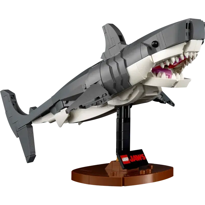 This LEGO model of a shark with an open mouth, displayed on a brown stand with a "Jaws" label, is perfect memorabilia for any fan of the iconic movie.