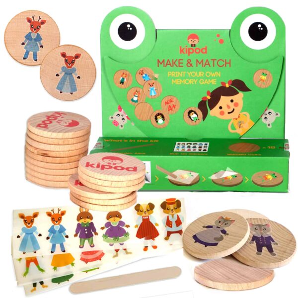 A children's memory game set titled "Make &amp; Match" by Kipod, featuring wooden coins with various printed images and a frog-themed box. This creative kit includes character stickers and a wooden tool for endless fun.