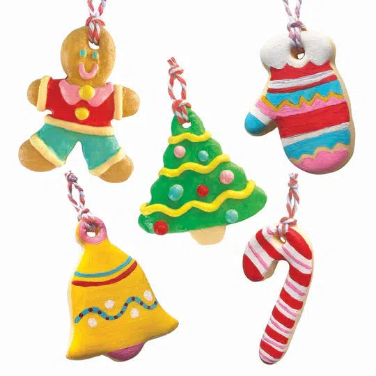 Five colorful, cookie-shaped ornaments crafted from air-dry clay—gingerbread person, Christmas tree, mitten, bell, and candy cane—hang on strings. Perfect for a festive activity that brings holiday cheer to life.