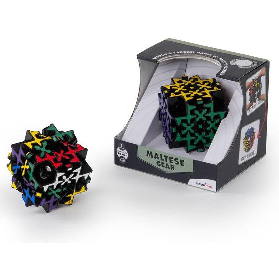 A colorful, complex brainteaser puzzle cube sits beside its packaging labeled "Meffert's Maltese Gear," inviting curious minds to explore the twisting gears within.