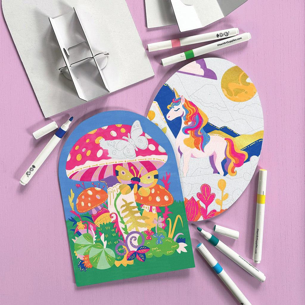 Colorful art supplies and two illustrated coloring sheets featuring a unicorn and mushrooms are displayed on a pink surface, brought to life with paint markers. The vibrant colors breathe life into each intricate art detail, creating enchanting scenes waiting to be explored.