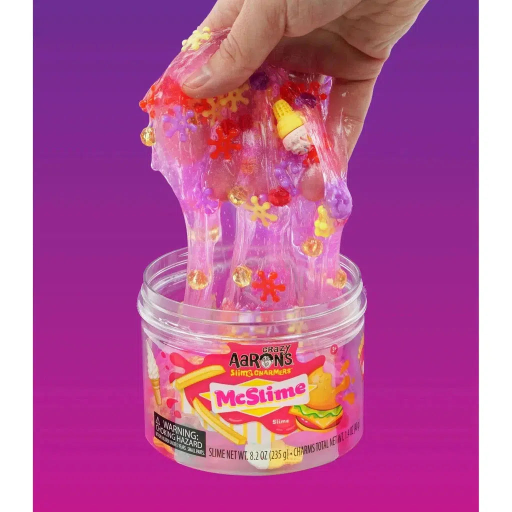 hand stretching the slime mixed with charms