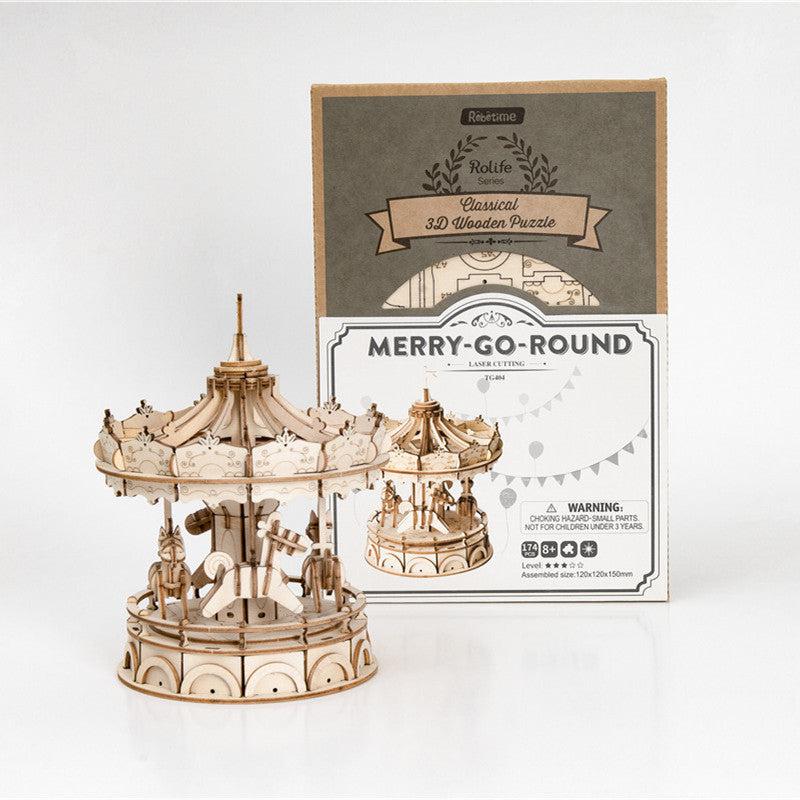 The tiny merry go round standing next to its packaging