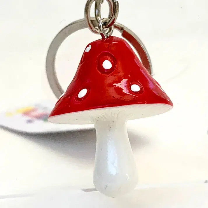 A Mushroom Key Charm featuring a small, red and white mushroom pendant with a smooth, glossy surface.