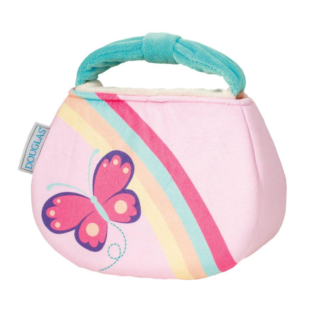 This pink fabric bag, designed for imaginative adventures, features a handle and is adorned with a rainbow and butterfly motif. A small label on the side proudly reads "Douglas," making it the perfect My First Purse for little dreamers exploring their world of plush accessories.