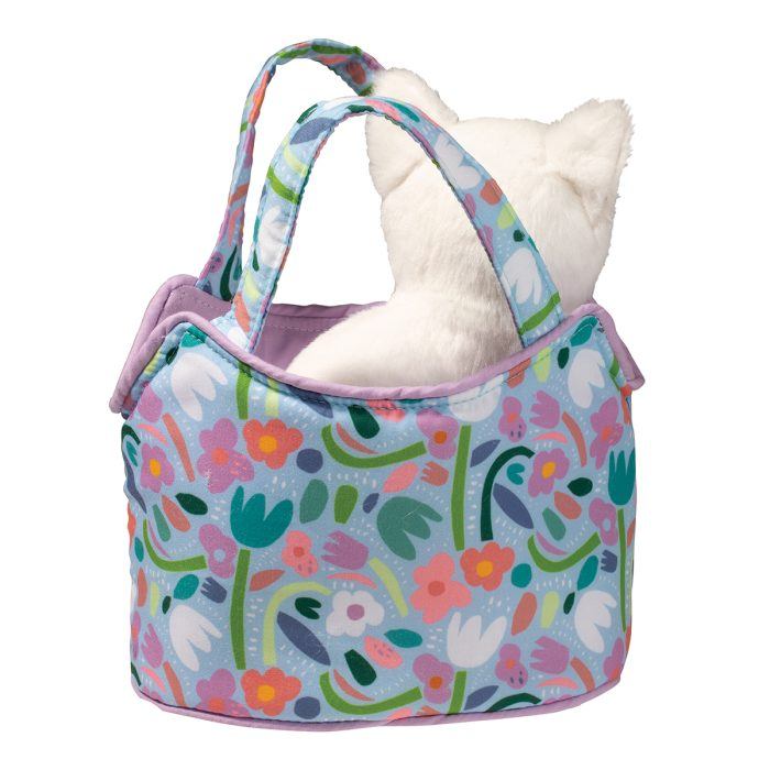 A plush white cat nestles inside a vibrant bag adorned with a floral pattern and purple trim, reminiscent of lively garden blossoms.