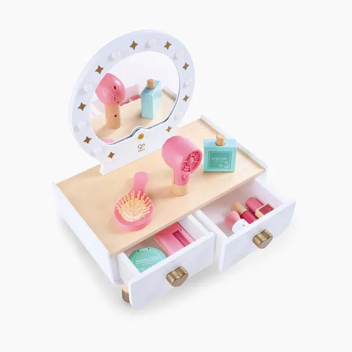 A toy vanity set featuring a light-up dressing table, mirror, two drawers with heart-shaped knobs, and various colorful accessories, including a hairbrush, hairdryer, and makeup items. Perfect for an imaginative playtime and a delightful makeup experience.