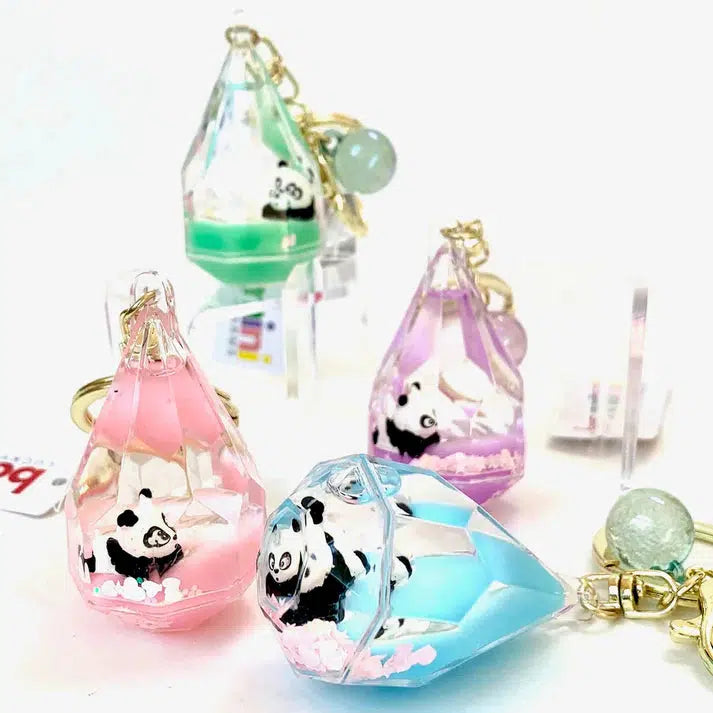 Discover our Diamond Floaty Key Charms: four crystal-shaped keychains featuring adorable panda figurines inside. Available in green, pink, blue, and purple, each charm dazzles with a gold clasp and decorative beads. Perfect for adding a touch of whimsy to your keys!.