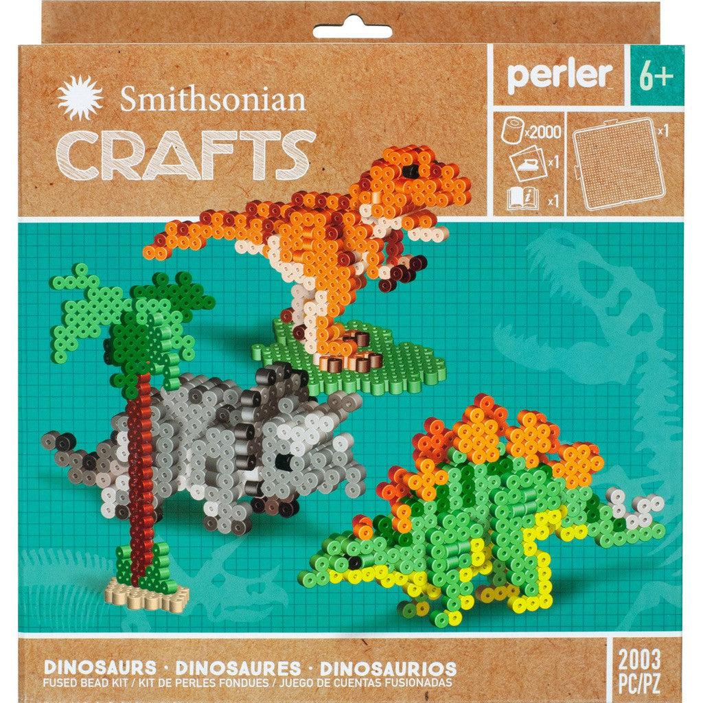 Front packaging of the Smithsonian Crafts Perler bead kit featuring dinosaur designs. Contains over 2000 beads and is suitable for ages 6 and up. Includes designs of a T-Rex, Triceratops, and Stegosaurus.