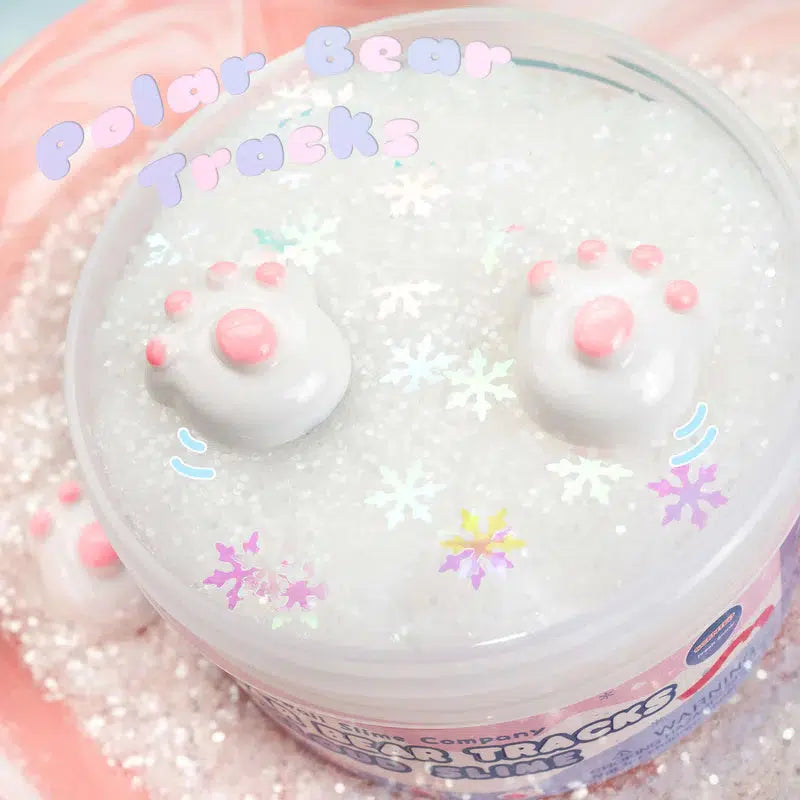 A container of cloud slime with pink bear paw charms and snowflake glitter, infused with a frosty musk, labeled "Polar Bear Tracks.